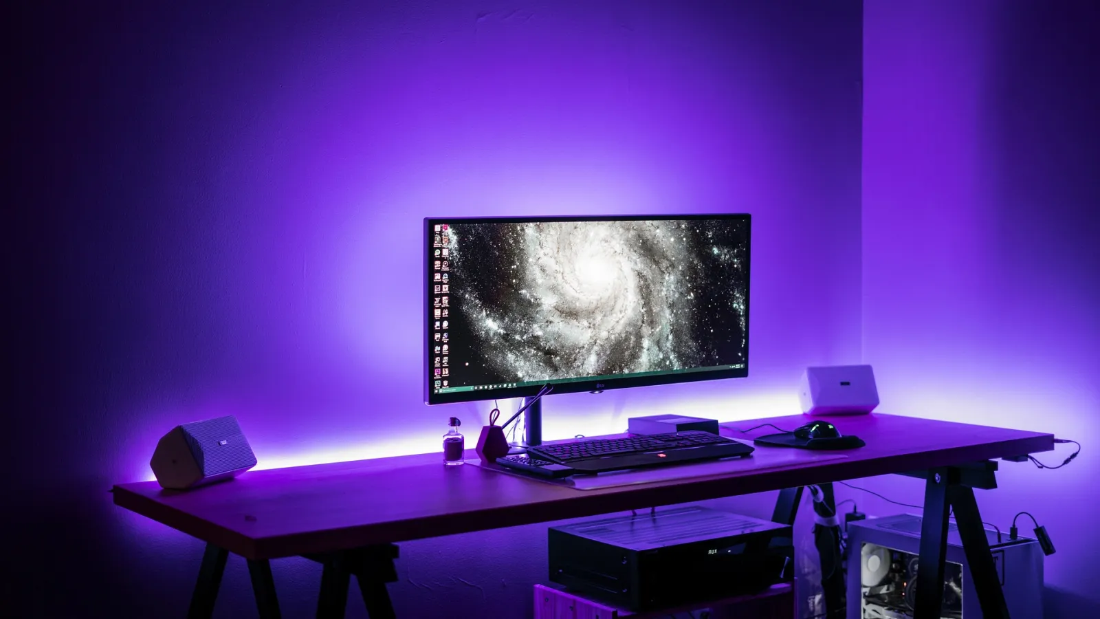 A desk with a widescreen monitor used for recording and editing video