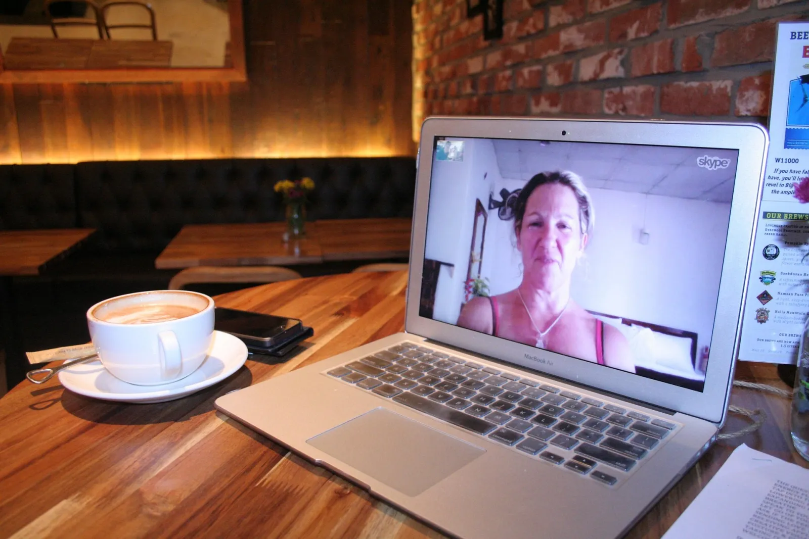 A MacBook on a table showing a video call